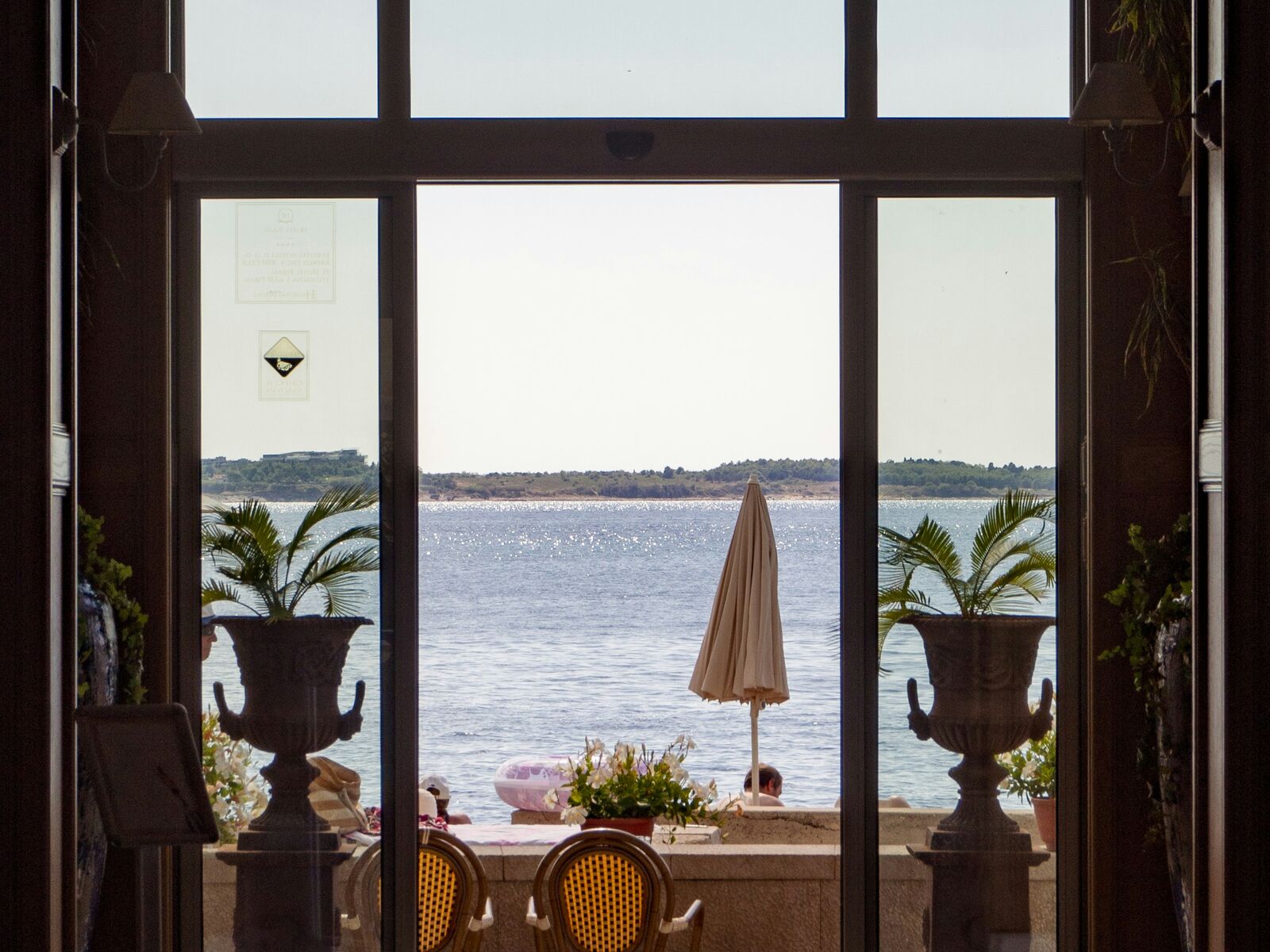 A hotel lobby opening onto a terrace with a view of the sea